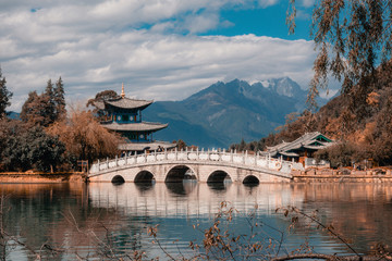 Beautiful view of the Jade Dragon Snow Mountain and the Suocui Bridge over the Black Dragon Pool in the Jade Spring Park, Lijiang,