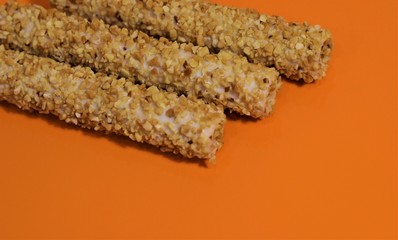 sweet rolls in the nuts on an orange table