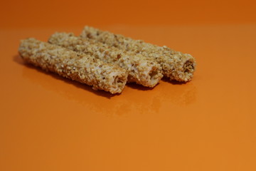 sweet rolls in the nuts on an orange table