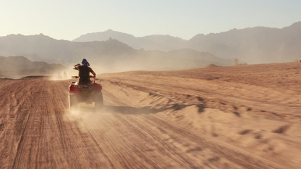 Quad bike ride through the desert near Sharm el Sheikh, Egypt.Adventures of desert off-road on ATV.Sand and Sand Borkhan. Rock and sunset. Quad Cycle Travel. Excursion with people. © Yaroslav