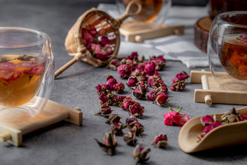 tea made from tea rose petals in a glass bowl on drak black rustic background