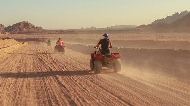 Quad bike ride through the desert near Sharm el Sheikh, Egypt.Adventures of desert off-road on ATV.Sand and Sand Borkhan. Rock and sunset. Quad Cycle Travel. Excursion with people.