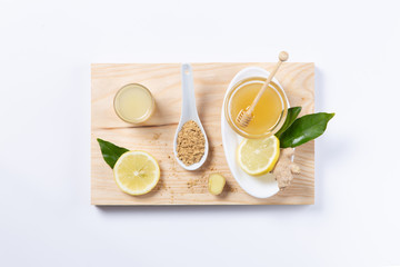 Ginger, honey and lemon, .in white plates and spoon on white background. Top view. Natutal food and brevage concept.