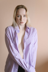 Sensual portrait of a young woman with blue eyes in pink shirt.