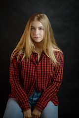 Fototapeta premium Portrait of beautiful woman with blue eyes in black-red shirt.