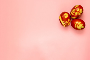 Easter eggs dyed with onion peels with a pattern of fresh leaves of plants on a pink background. Minimal flat lay. Easter postcard with copy space for text. Mockup