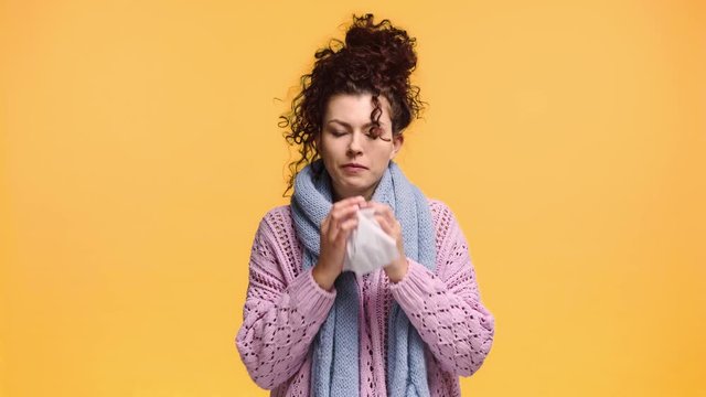 diseased woman sneezing in tissue isolated on orange