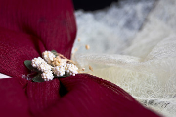Obraz na płótnie Canvas Lazada roja con adornos de pequeñas flores para vestido blanco