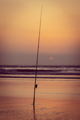Silhouette of fishing rod at sunset