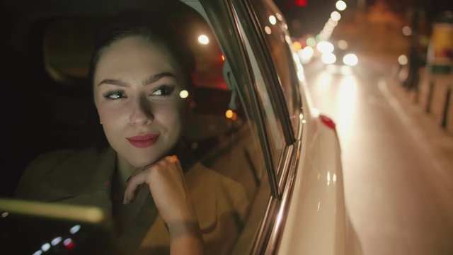 Young brunette Businesswoman in the taxi is reading messages on her tablet