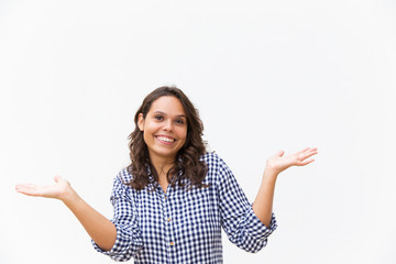 Joyful clueless student girl shrugging, looking at camera and smiling. Young woman in casual checked shirt standing isolated over white background. Do not know concept