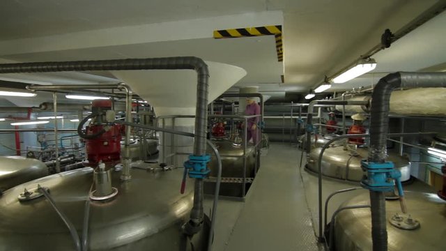 Ice cream production. Shiny steel metal pipes and tanks. Steel tanks in the interior of a modern factory. Steel, modern, shiny pipeline is covered with droplets of condensate.