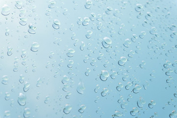 Raindrop water dew drop on glass wet white gray blue background.