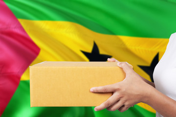 Sao Tome And Principe delivery service. International shipment theme. Woman courier hand holding...