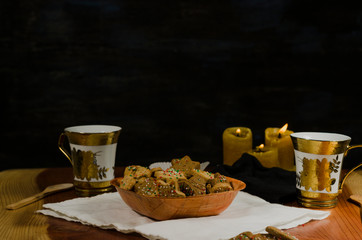 Plate and cups with delicious ginger cookies, cinnamon, chocolate, vanilla, on the table, closeup view Christmas