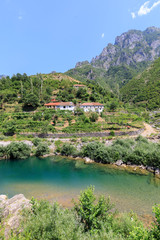 Fototapeta na wymiar Crystal clear river with a typical Albanian house in the Dinaric Alps of Albania