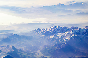 View from the airplane porthole to a mountain landscape