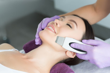 Obraz na płótnie Canvas woman receiving ultrasound cavitation facial peel. get clean face without blackheads and skin defects using ultrasound equipment
