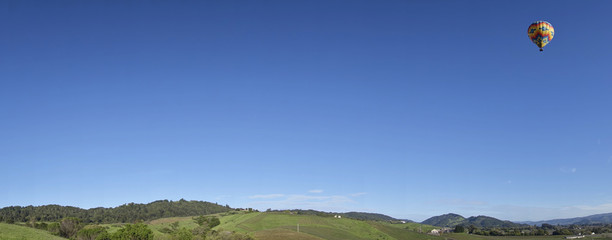 A hot air balloon floats off over the Napa Valley.