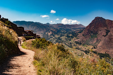 Snowy mountains with blue sky and white clouds, big hills with green pastures.