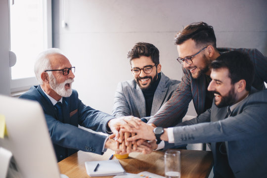 A managerial team starting a new project under the wise guidance of a senior executive who inspires teamwork.