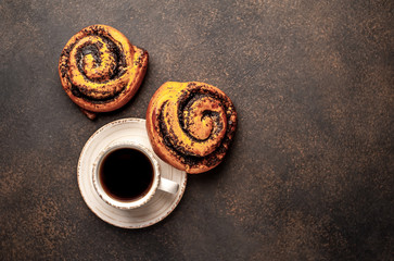 coffee and bun with poppy seeds on a stone background. breakfast concept