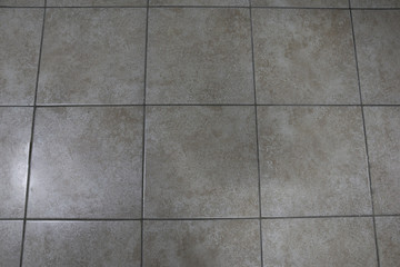 Tiled gray tiles, large brick tiles. Floor tiles with gray stains.
