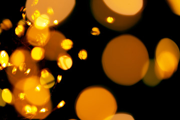 Black background with bright warm bokeh lights. Holiday, Christmas and New Year background. Ideal to layer with any design. Horizontal