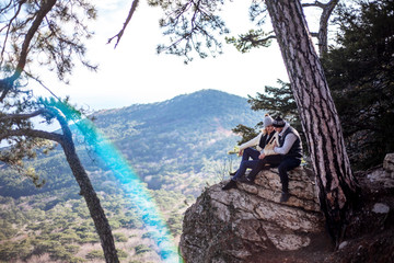 Couple in relationship, man  holding the woman hand.  people look to the beautiful view of to of mountains, sky and sea on the observation deck for lovers. the rainbow hit in the camera