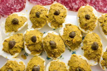 Appetizer with stuffed eggs and sliced salami
