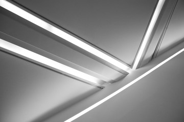 Ceiling with backlit girders and lamps. Abstract architecture fragment. Modern office building...