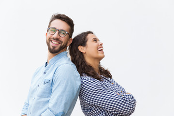 Joyful carefree couple leaning on each other, chatting and laughing at joke. Young woman in casual and man in glasses in glasses posing isolated over white background. Sweet couple concept