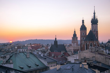 Fototapeta na wymiar Zachód słońca nad starym miastem w Krakowie, Bazylika Mariacka, Ratusz, Sukiennice, Polska