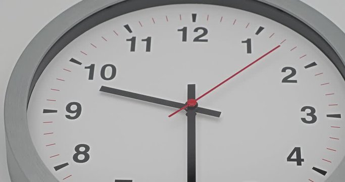 Truck shot of time-lapse gray clock with black arrows shows motion the time speed up from 9.00 and slow down to 10.00, How time flies concept.