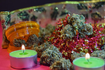 dried cannabis flowers and grinder with christmas decorations to celebrate the new year