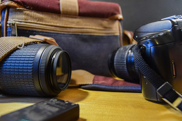 Fototapeta na wymiar camera, lens and transport backpack on an oak table analog photographic equipment