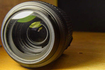 detail of a camera lens on an oak table. professional photographic equipment