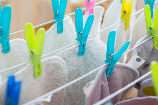 Diapers laundry indoors . Eco nappy wash drying in a room . Colorful diapers drying.Pop-in Reusable Nappy