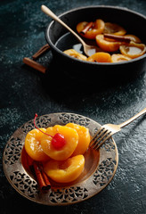 Peach dessert with cinnamon and  cherry.