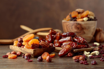 Various dried fruits and nuts in wooden dish. - obrazy, fototapety, plakaty