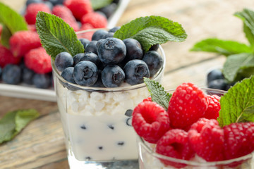 Cottage cheese with cream, raspberry and blueberry garnished with fresh mint.