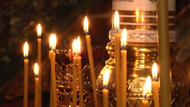 Burning candles in a Russian ortodox church. Close-up of ordinary church interior. Selective focus.  symbol of faith and Christianity: a candlestick with burning candles in the temple in darkness 