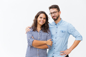 Naklejka premium Cheerful couple hugging and posing. Young woman in casual and man in glasses standing isolated over white background. Happy young couple concept
