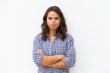Positive determined student girl with arms crossed and funny grimace looking at camera. Young woman...