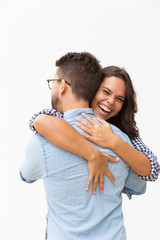 Joyful excited beautiful woman hugging boyfriend. Young woman in casual and man in glasses posing isolated over white background. Sweet couple or affection concept