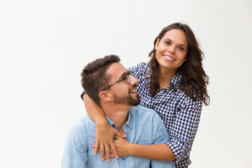 Happy sweet couple having fun, hugging and posing. Young woman in casual and man in glasses standing isolated over white background. Love and friendship concept