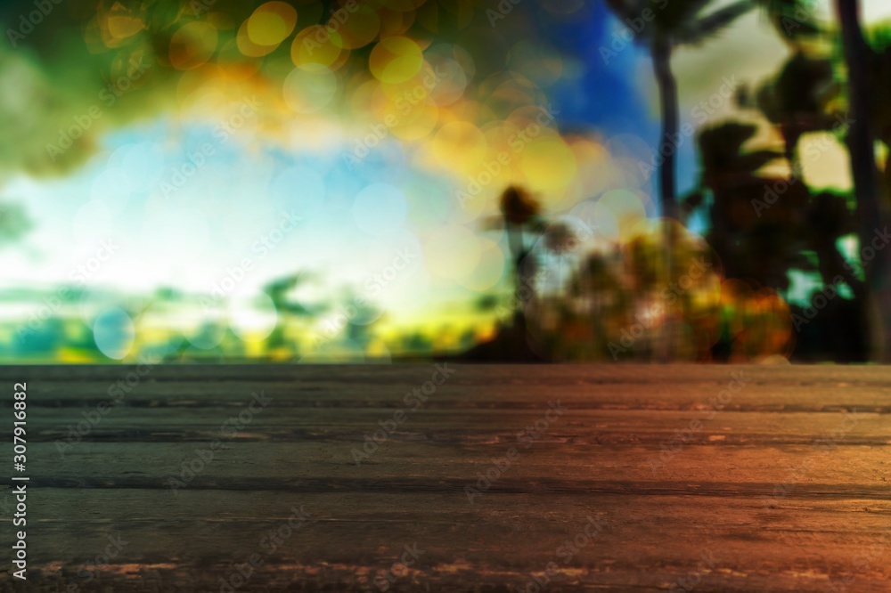 Sticker background Image of wooden table in front of abstract blurred tropical palms at sunset lights