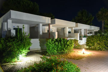 Fototapeta na wymiar Night Modern Homes with Illuminated Path by Summer
