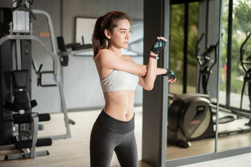 Fototapeta na wymiar Beautiful asian woman is doing exercise in the gym