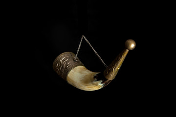 Horn for wine on chain on black background